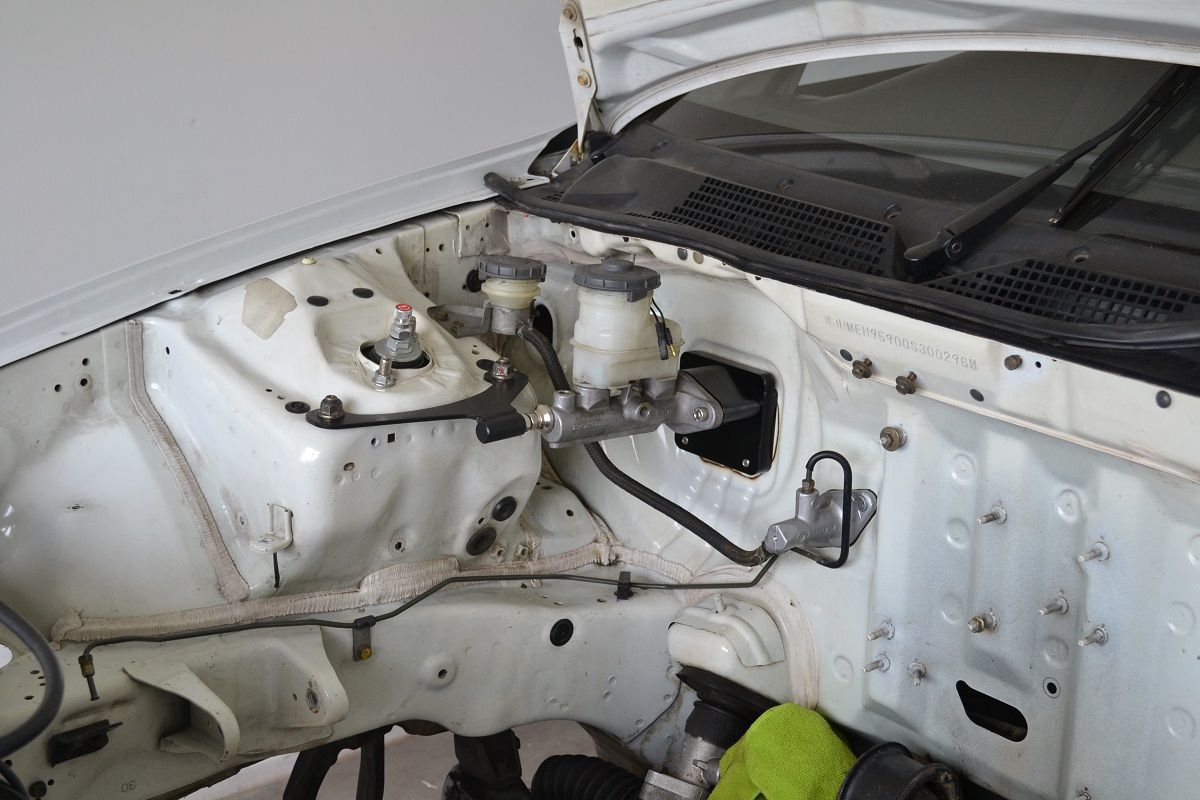 Honed's Booster Delete Kit installed in the engine bay of a Honda Civic